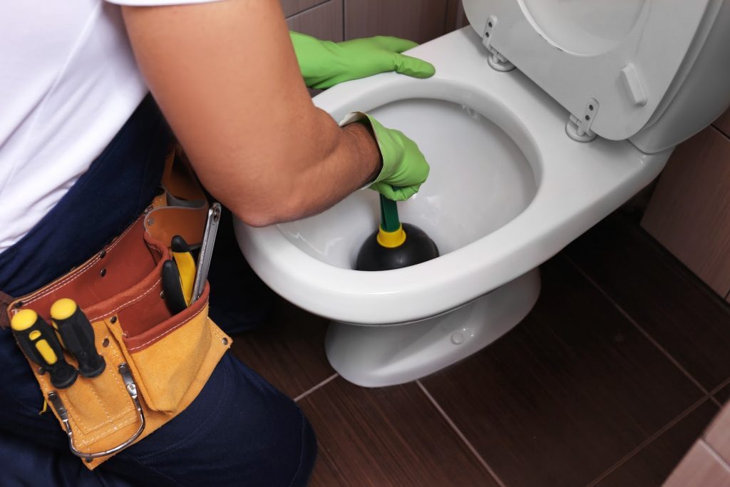 Man plunging toilet with tools 1024x683 1024x683 1