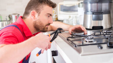 handyman fixing gas stove in the kitchen